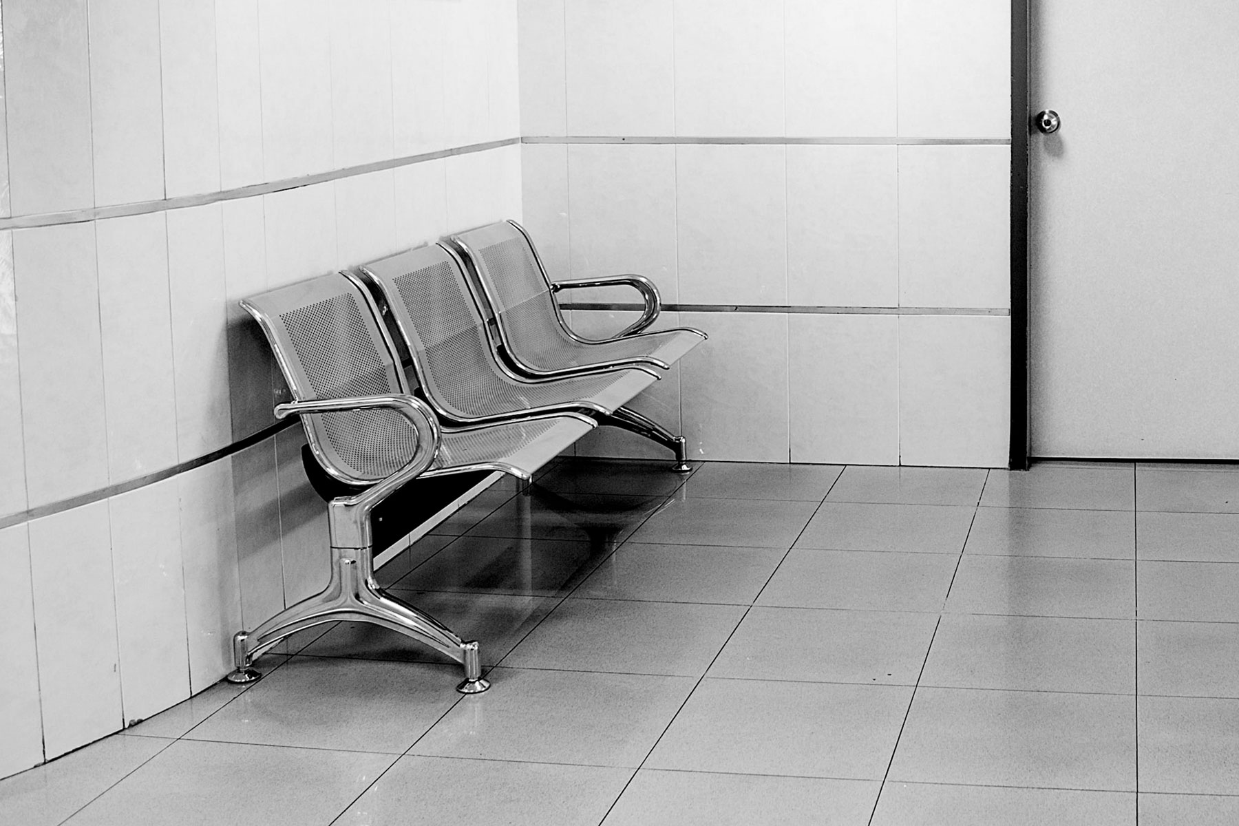 Three empty chairs in a waiting room.